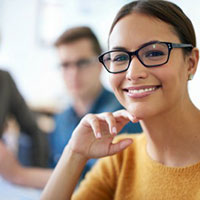 smiling woman in glasses sitting in a meeting