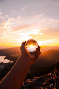 Hand holding sphere during sunset