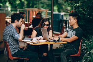 Three people at table with laptop