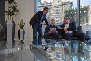 3 male colleagues at reflective coffee table