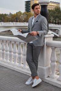 person leaning on banister reading a newspaper