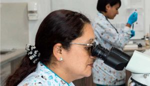 woman looking through microscope