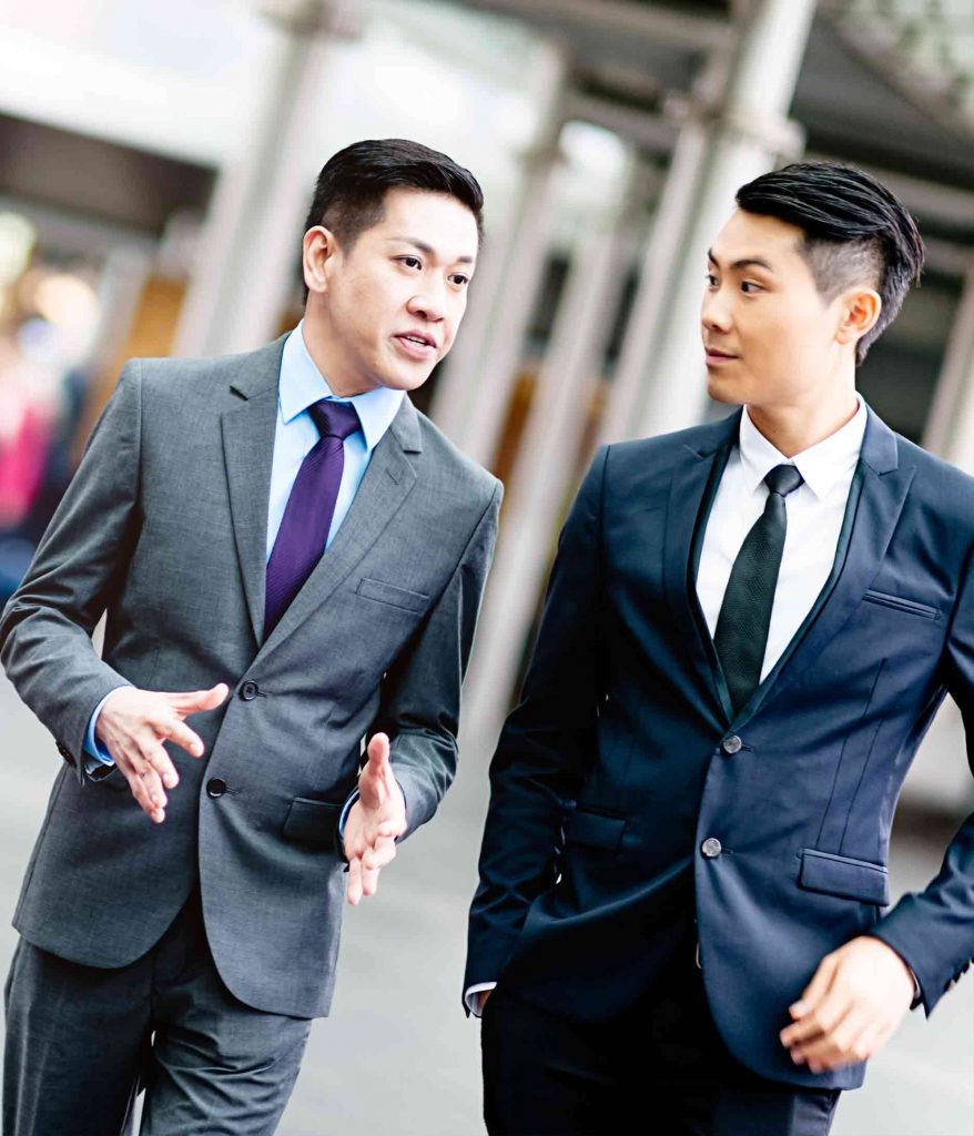 two Asian businessmen in street