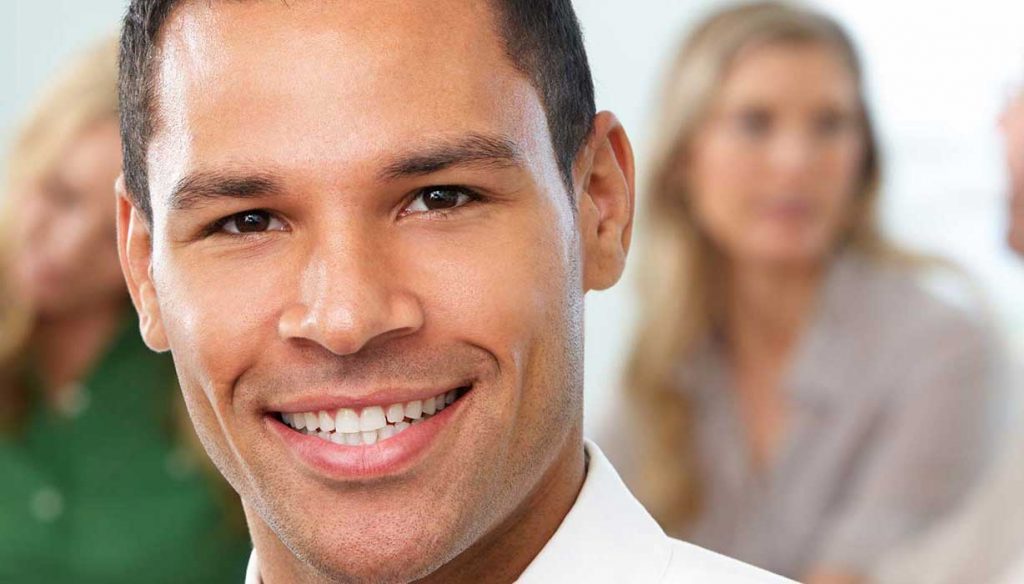 Hispanic man closeup with woman in the background