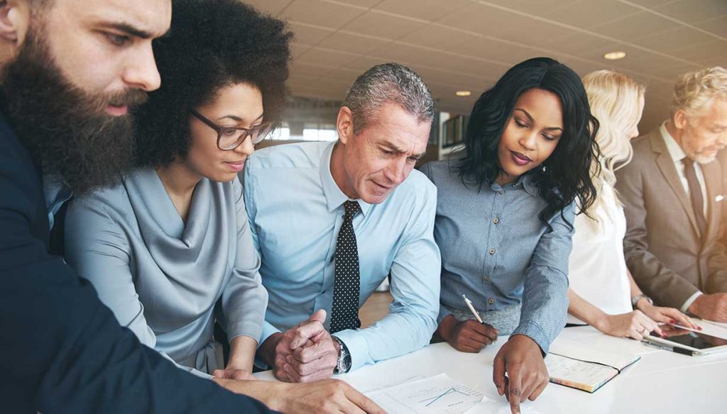 Contemporary multiracial team working on project in office