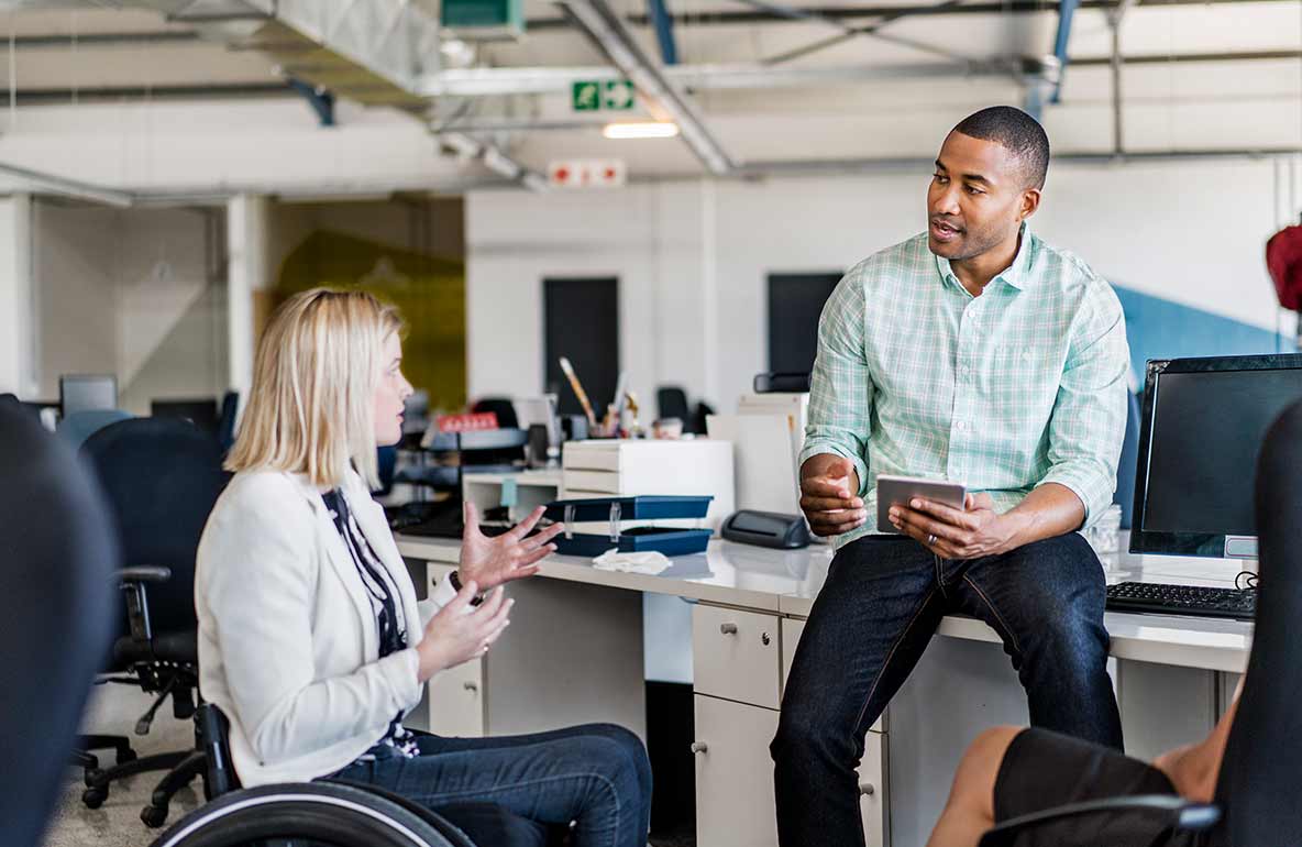 woman in wheelchair talking with man