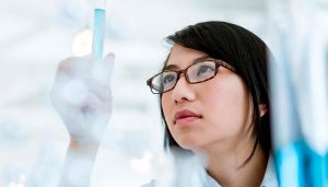 scientist looking at test tube