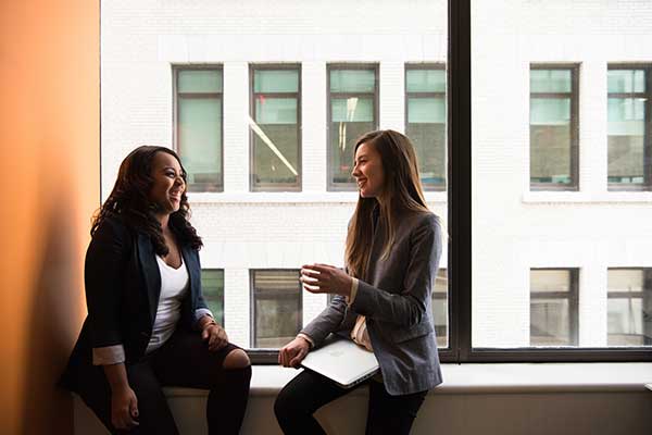 two workers sitting on window sill