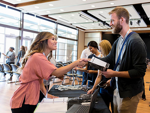 Two people communicating at a job fair