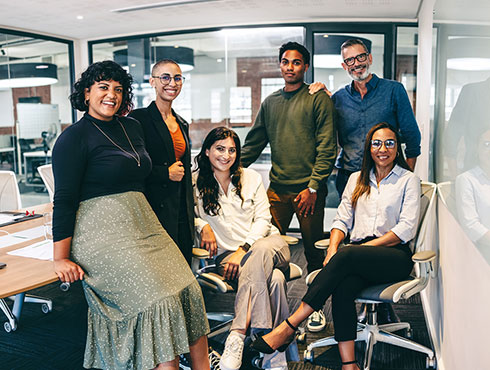 six smiling co-workers in a conference room