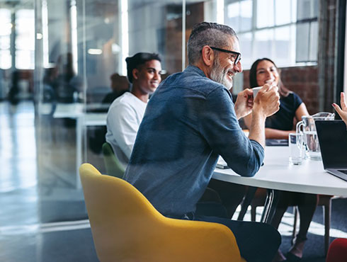 Cheerful businessman attending a meeting with his team