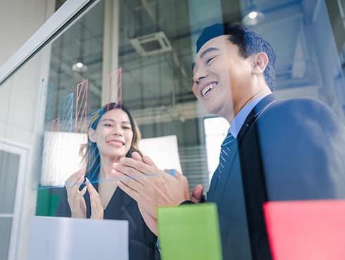 two people in an office looking through glass