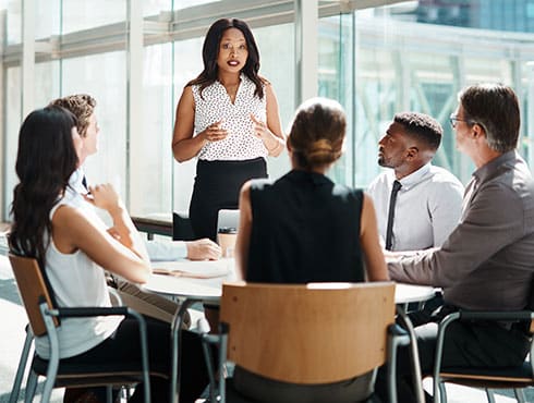 several people sitting around a table in a meeting